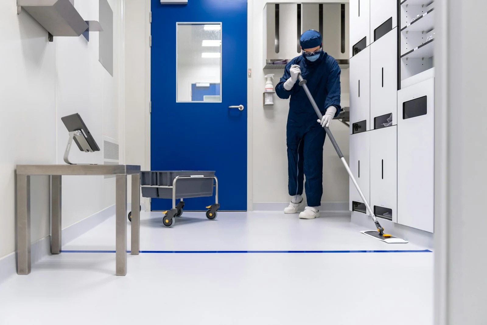 Profissional realizando a limpeza de um ambiente interno.